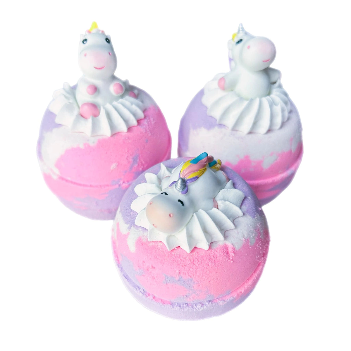 Pink purple and white bath bombs with surprise unicorn toys in bubble bath frosting.